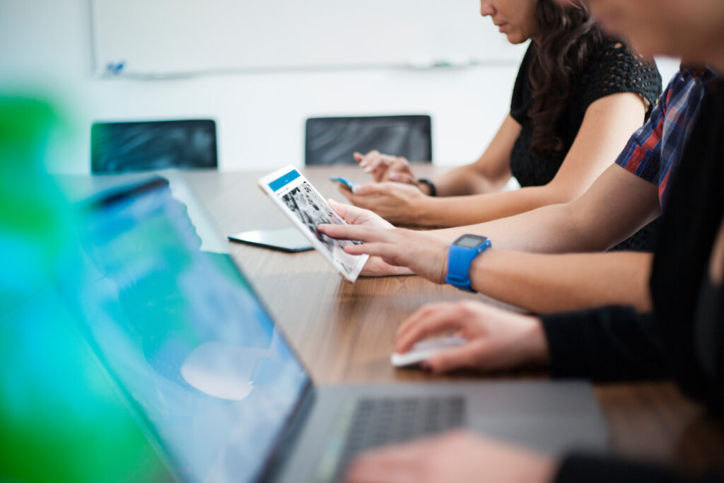 Picture of team members collaborating on multiple devices.