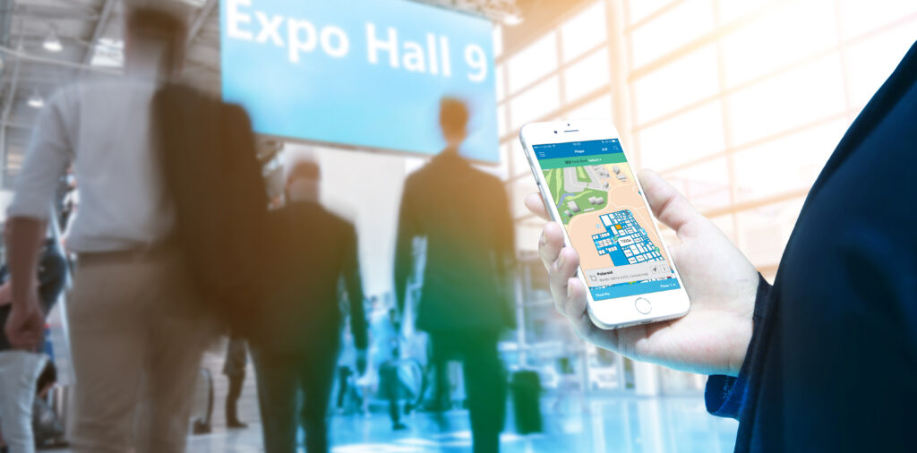 Person holding a smartphone while navigating a convention hall with the Deep Map.
